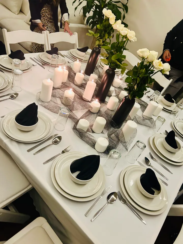 Montajes en blanco y negro con velas y rosas blancas en una cena a la luz de las velas