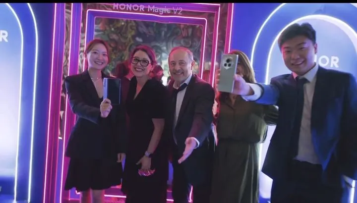 Guests taking a selfie at the HONOR Magic V2 launch in front of a branded backdrop