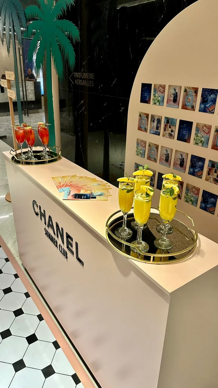 Gold trays of orange and yellow cocktails on the Chanel Summer Club bar counter
